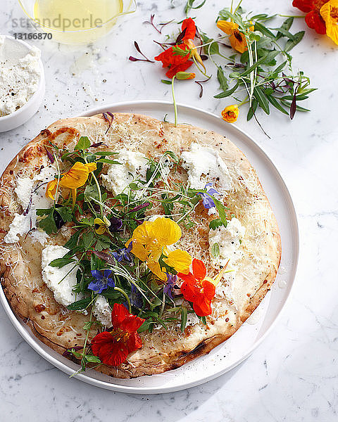 Pizzateller mit Käse und Blumen