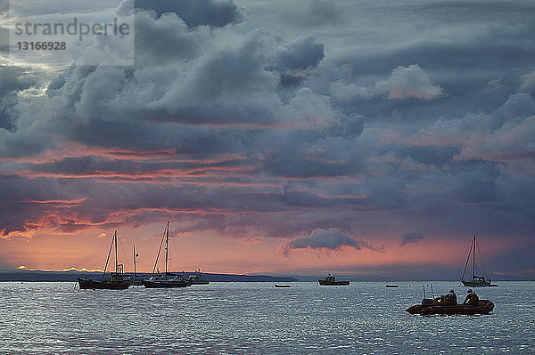 Boote als Silhouette bei Sonnenaufgang  Tenby  Wales  UK