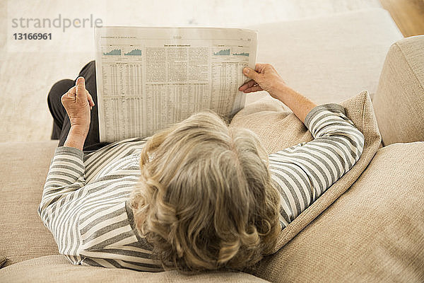 Ältere Frau liest die Zeitung