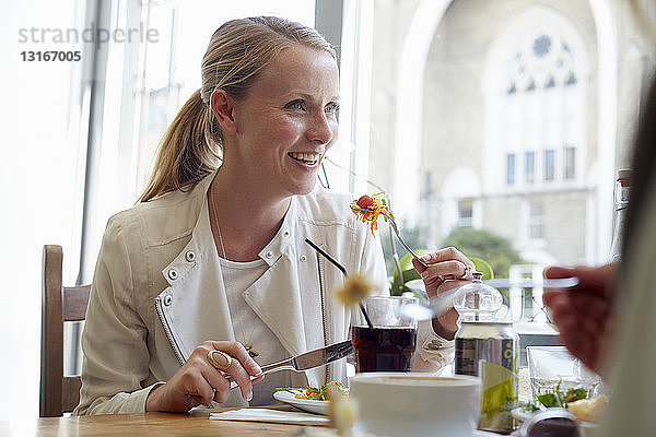 Mittlere erwachsene Frau beim Mittagessen mit Freundin im Café