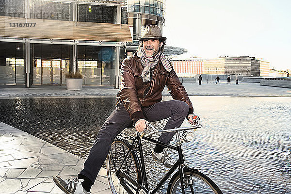 Mittelgroßer erwachsener Mann genießt Fahrradfahren in der Stadt