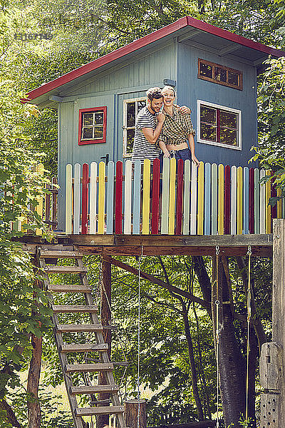 Junges Paar im Baumhaus stehend  umarmend  lachend