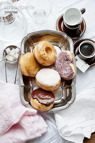 Tablett mit Donuts mit Kaffee und Zucker