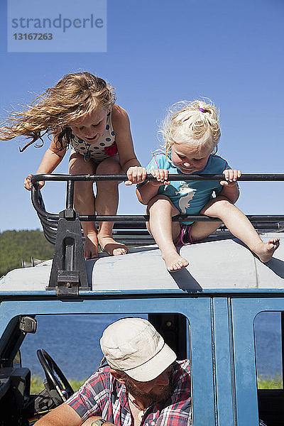 Zwei Schwestern schauen vom Geländewagen herab  Lake Okareka  Neuseeland