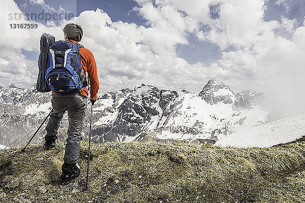 Junger Mann betrachtet Aussicht in den bayerischen Alpen  Oberstdorf  Bayern  Deutschland