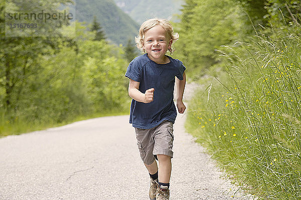 Junge läuft auf Landstraße  Bovec  Soca  Slowenien
