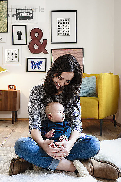 Mutter und kleiner Sohn sitzen im Wohnzimmer