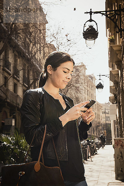 Frau mit Smartphone auf der Straße  El Born  Barcelona  Spanien