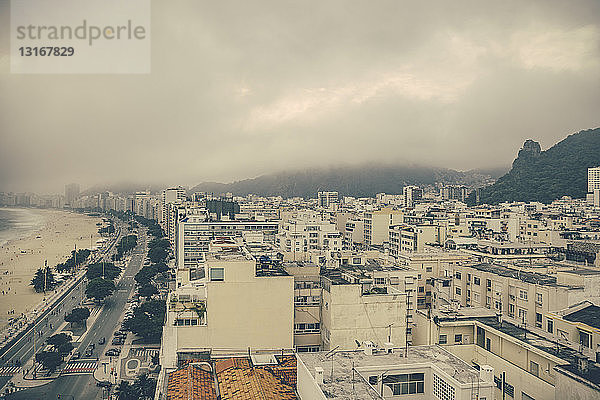 Erhöhtes Stadtbild mit niedriger Bewölkung über dem Strand von Copacabana  Rio de Janeiro  Brasilien
