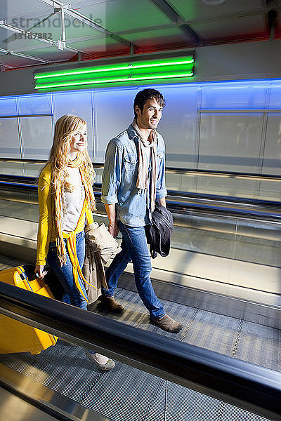 Ehepaar auf Fahrsteig im Flughafen