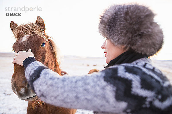 Reife Frau streichelt Pony