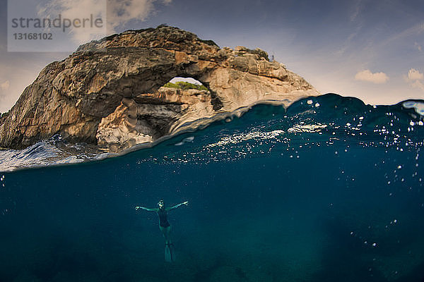 Frau unter Wasser mit Bogen  Santany  Mallorca  Spanien
