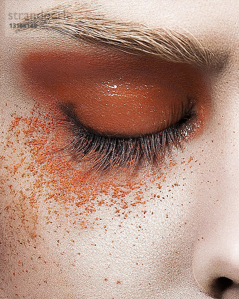 Junge Frau mit orangefarbenem Augen-Make-up  Nahaufnahme des Auges
