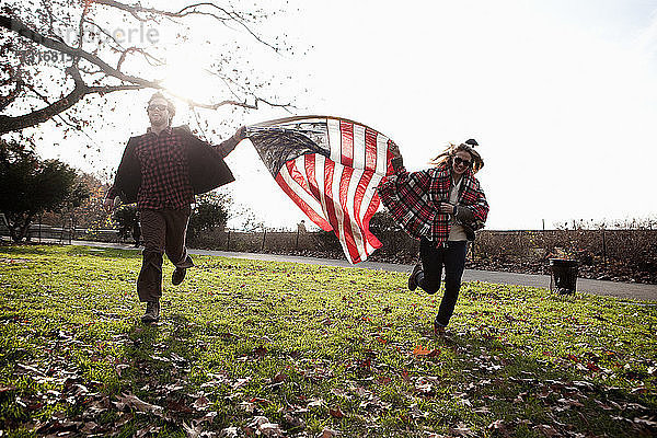 Freunde laufen mit amerikanischer Flagge