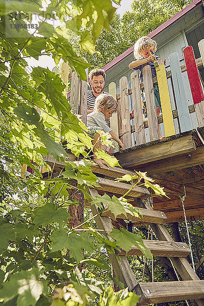 Vater und zwei Söhne  malen Baumhaus  Niedrigwinkelansicht