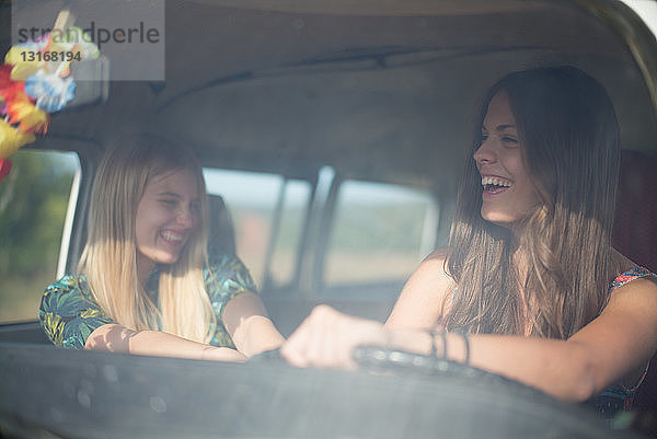 Zwei junge Frauen im Wohnmobil  lachend