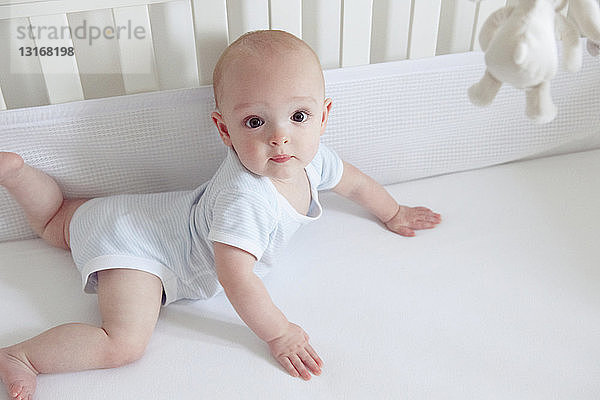 Baby Junge krabbelt im Kinderbett