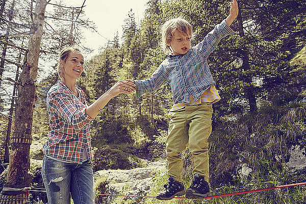 Junge balanciert auf Seil mit Hilfe der Mutter  Ehrwald  Tirol  Österreich