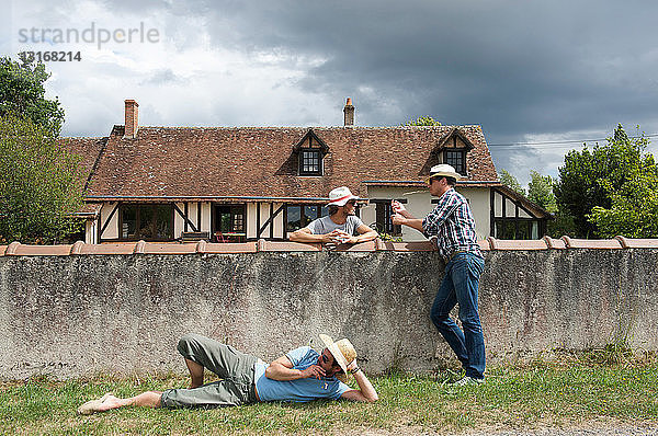 Männer entspannen sich auf ländlicher Mauer