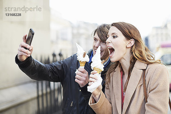 Paar mit Eiswaffeln nimmt Smartphone-Selfie  London  UK