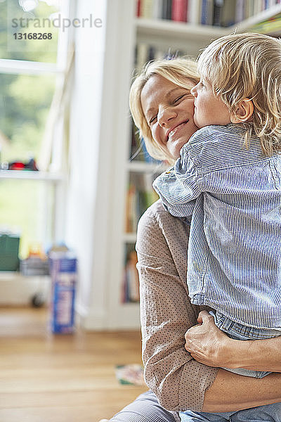 Mutter und Sohn umarmen sich  lächeln