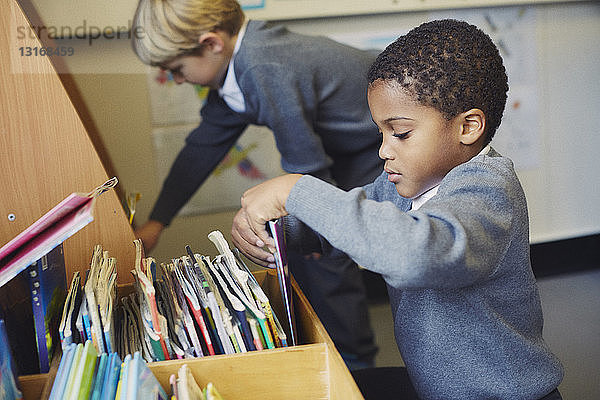 Zwei Jungen wählen Bücher in der Grundschulklasse