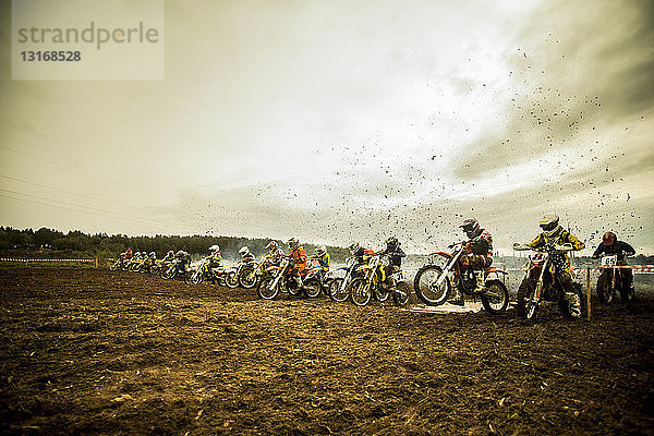 Gruppe von Jungen auf Motorrädern an der Motocross-Startlinie