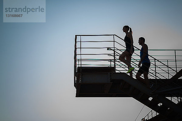 Mann und Frau gehen die Treppe hinauf  Silhouette