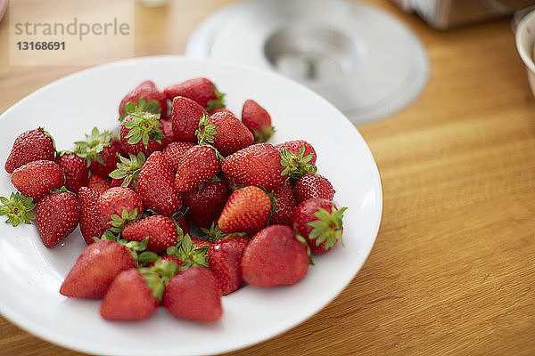 Teller mit Erdbeeren auf dem Esstisch