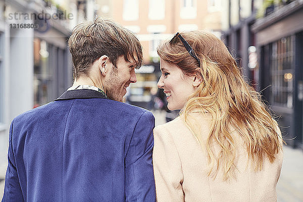Rückansicht eines schlendernden Paares auf der Straße  London  UK