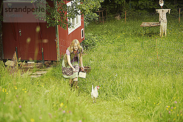 Frau auf dem Feld bei der Hühnerjagd