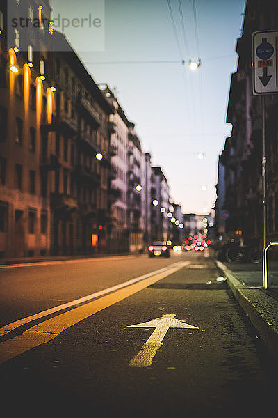 Straße mit Pfeilmarkierung in der Dämmerung  Mailand  Italien