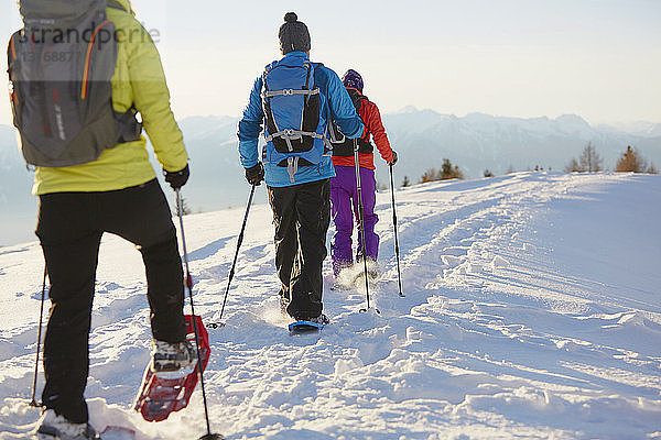 Drei mittlere erwachsene Freunde beim Schneeschuhwandern in den Dolomiten  Eisacktal  Südtirol  Italien