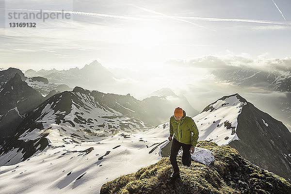 Junger männlicher Bergwanderer auf dem Gipfel eines Bergrückens in den bayerischen Alpen  Oberstdorf  Bayern  Deutschland