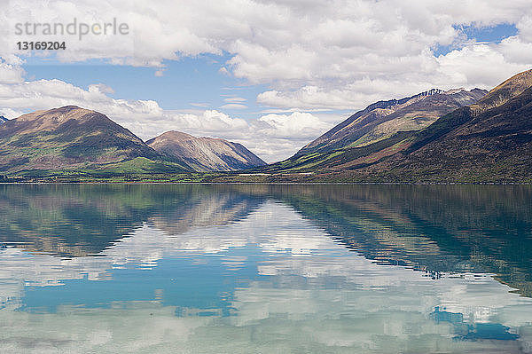 Wolken und Himmel spiegeln sich im stillen See