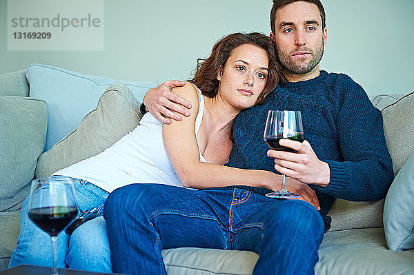 Ehepaar genießt Wein auf dem Sofa