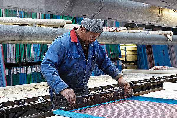 Mann Siebdruck in Textilfabrik
