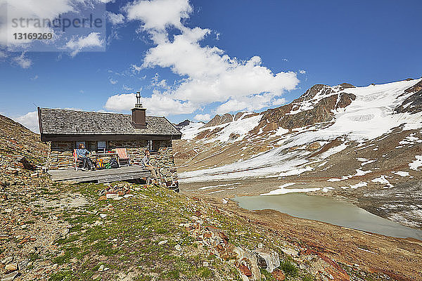 Junges Wanderpaar macht Rast vor der Hütte  Schnalstaler Gletscher  Schnalstalstal  Südtirol  Italien