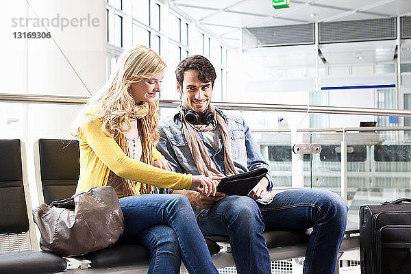 Ehepaar mit Tablet-Computer im Flughafen