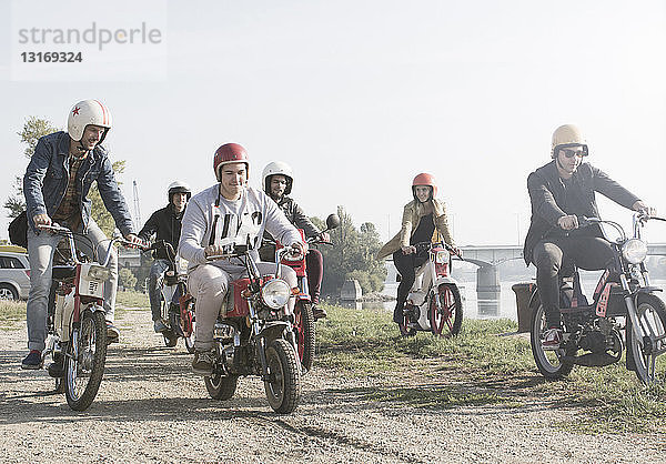 Gruppe von Freunden auf Moped am See