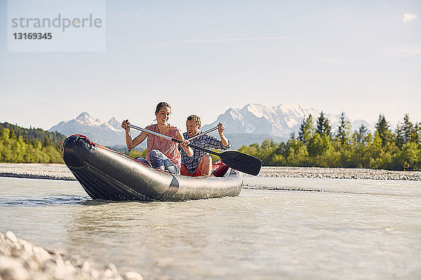 Ehepaar mit Paddel zum Steuern eines Beibootes auf dem Wasser  Wallgau  Bayern  Deutschland