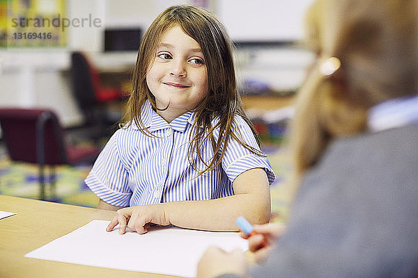 Zwei Mädchen zeichnen am Schreibtisch im Klassenzimmer der Grundschule