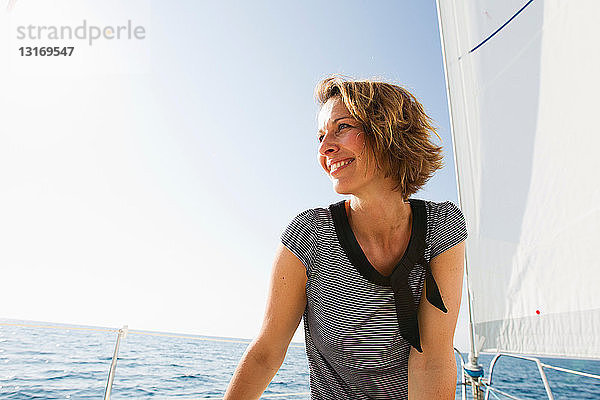 Lächelnde Frau steht auf Boot