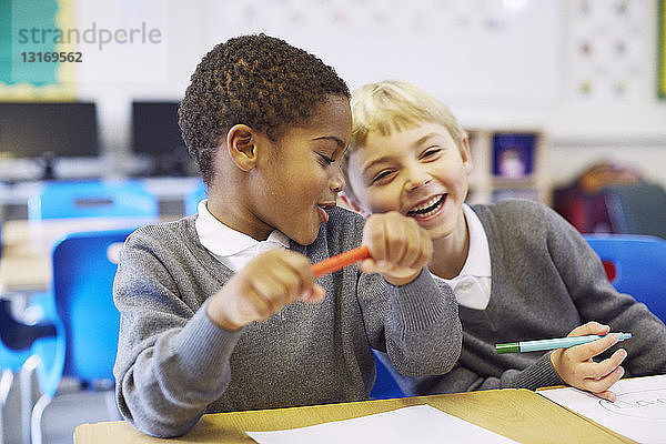 Spitzbübische Jungen im Klassenzimmer der Grundschule