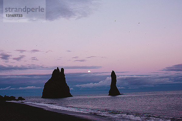 Silhouette von Felsformationen an der Küste bei Sonnenuntergang  Vik  Island