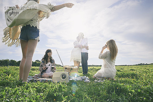 Fünf junge erwachsene Freunde machen ein Picknick auf dem Feld