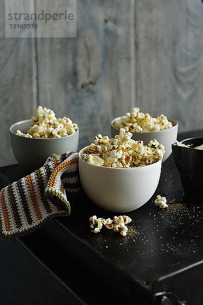 Schalen mit aromatisiertem Popcorn auf dem Tisch