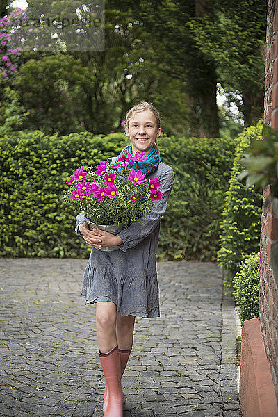 Bildnis eines Mädchens mit Blumentopfpflanze im Garten