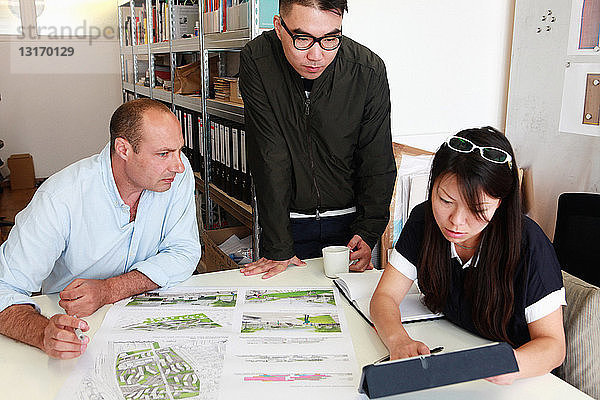 Team von drei Architekten begutachtet Ideen für Entwurf im Büro