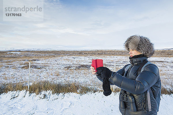 Reife Frau fotografiert auf schneebedecktem Feld  Island